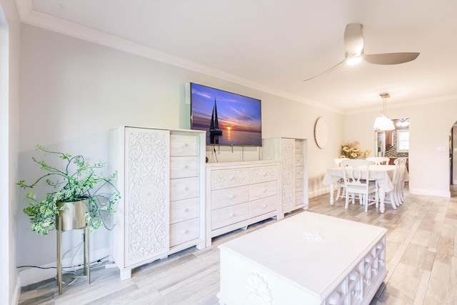 living room featuring crown molding, a ceiling fan, baseboards, and light wood finished floors