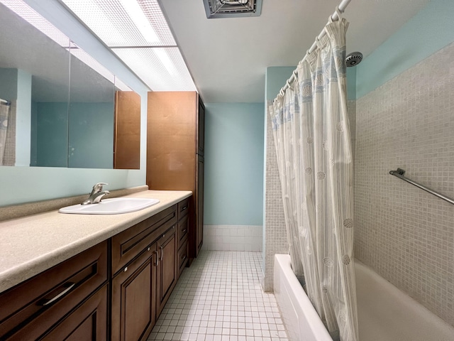 bathroom with tile patterned floors, shower / tub combo with curtain, vanity, and tile walls