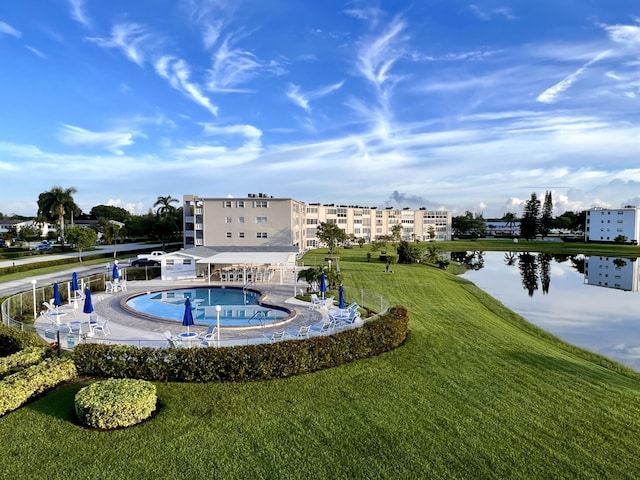 view of swimming pool featuring a yard and a water view