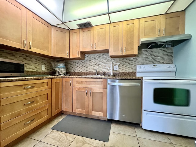 kitchen featuring backsplash, sink, light tile patterned floors, and stainless steel appliances