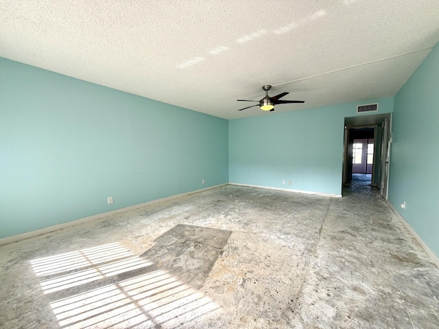 empty room with ceiling fan and a textured ceiling