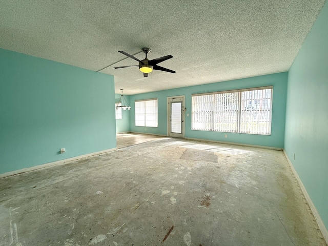 unfurnished living room featuring ceiling fan and a textured ceiling