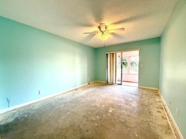 empty room with ceiling fan, concrete floors, and a textured ceiling