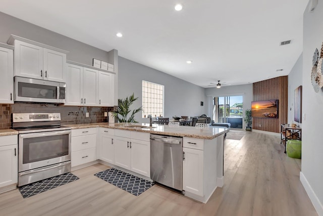 kitchen featuring white cabinets, appliances with stainless steel finishes, sink, kitchen peninsula, and ceiling fan