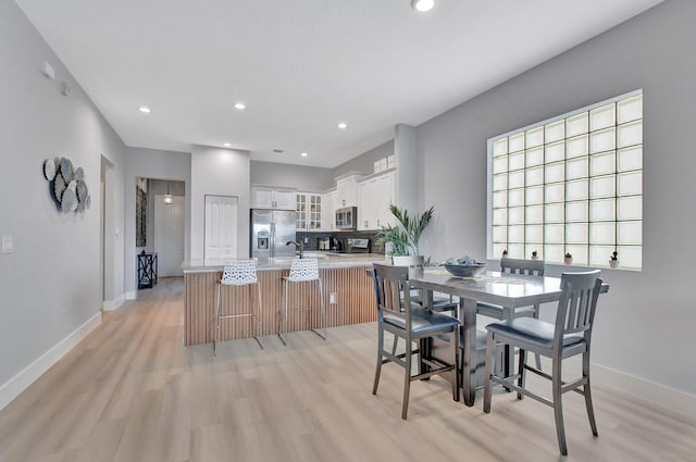 dining space with light wood-type flooring and sink