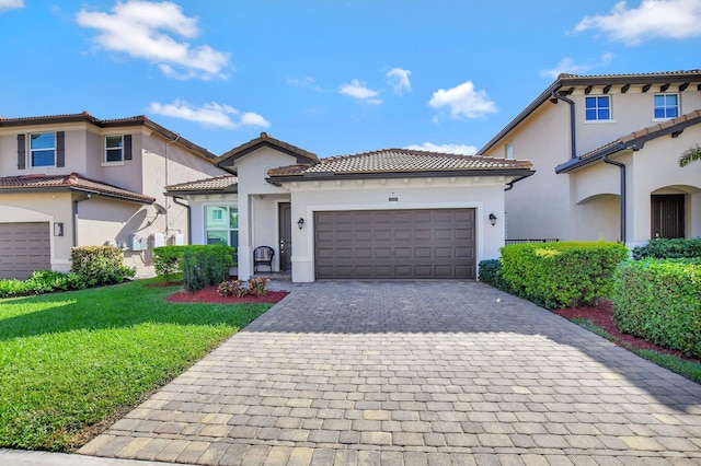 mediterranean / spanish house with a front lawn and a garage