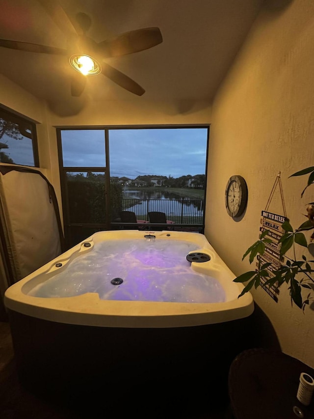 interior space with a water view and ceiling fan