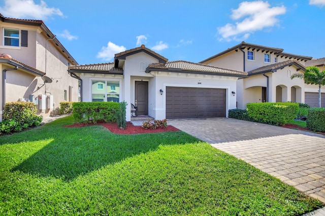 mediterranean / spanish home with a front lawn and a garage