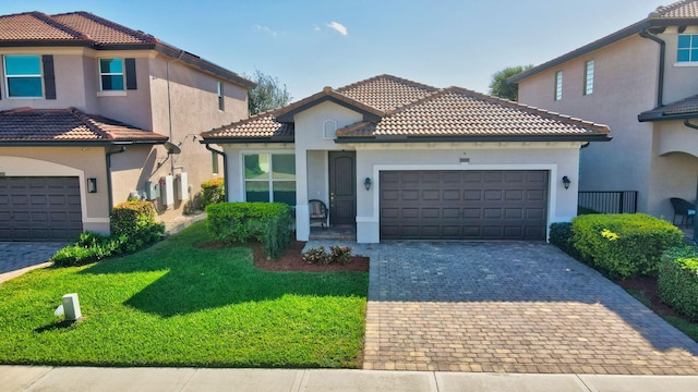 mediterranean / spanish house featuring a garage and a front yard