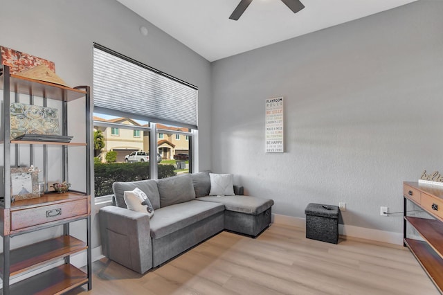 living room with ceiling fan and light hardwood / wood-style flooring