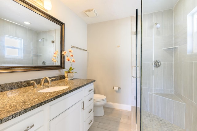 bathroom featuring vanity, toilet, and a shower with door