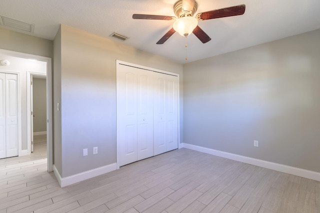 unfurnished bedroom featuring a closet, light hardwood / wood-style flooring, and ceiling fan