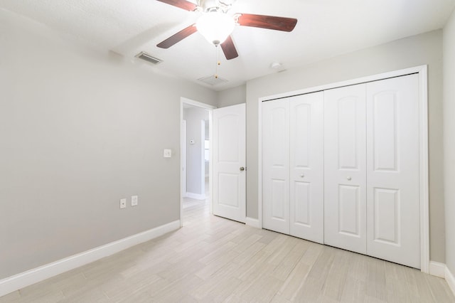 unfurnished bedroom with a textured ceiling, light wood-type flooring, a closet, and ceiling fan