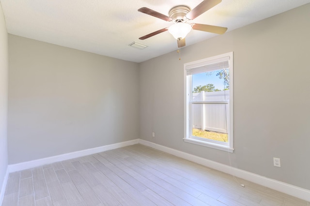 unfurnished room featuring a wealth of natural light, light hardwood / wood-style flooring, and ceiling fan