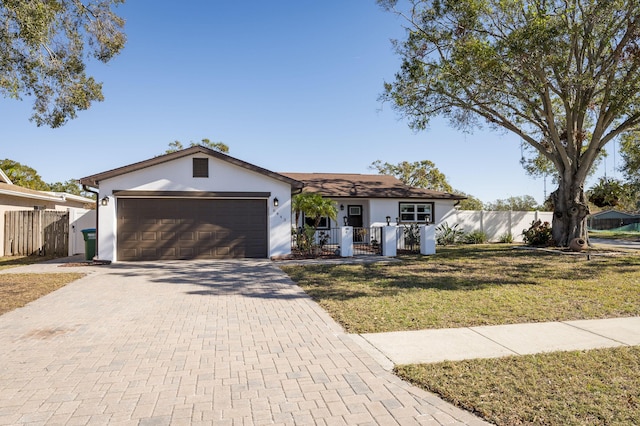 single story home with a garage and a front lawn