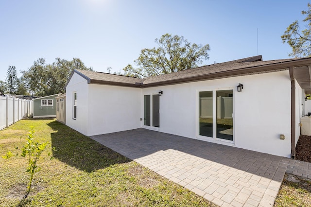 back of property featuring a yard and a patio