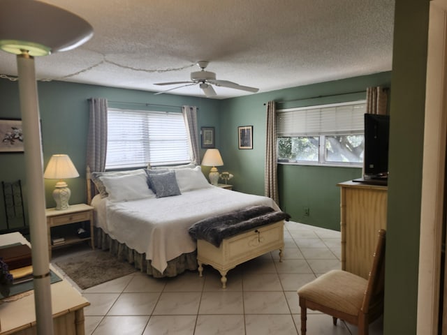 tiled bedroom featuring ceiling fan and a textured ceiling