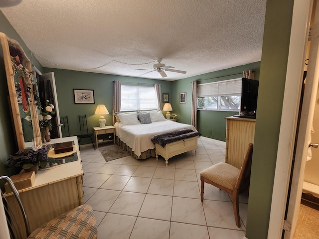 tiled bedroom featuring ceiling fan and a textured ceiling