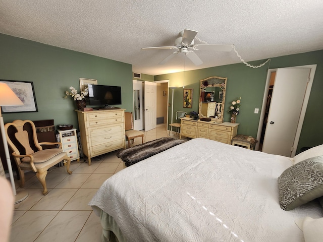 tiled bedroom with ceiling fan and a textured ceiling