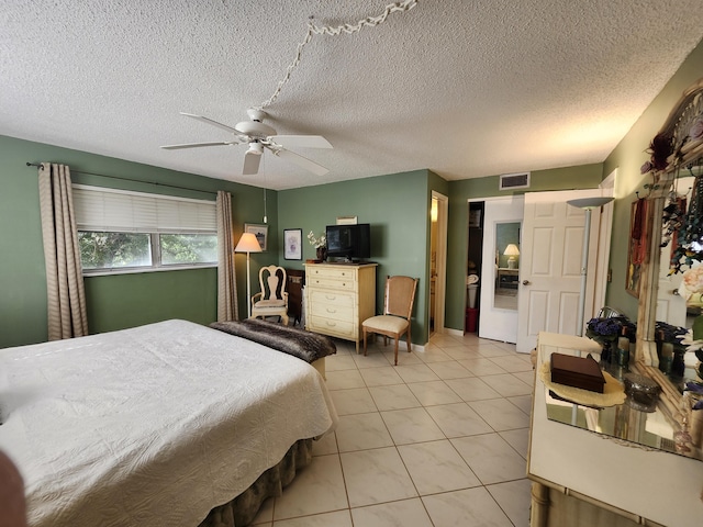 tiled bedroom with a textured ceiling and ceiling fan