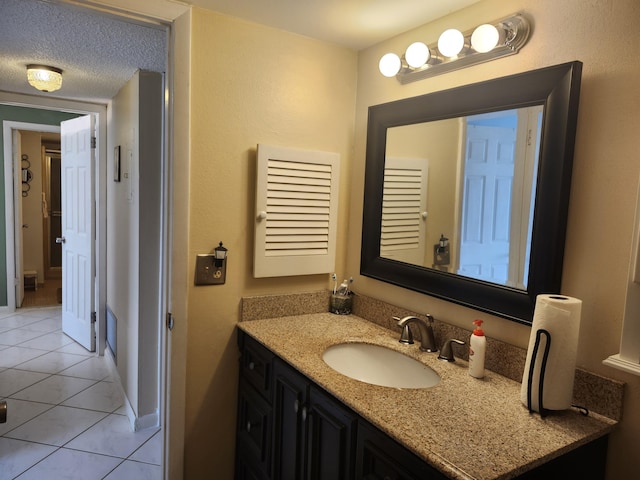 bathroom with tile patterned flooring, a textured ceiling, and vanity