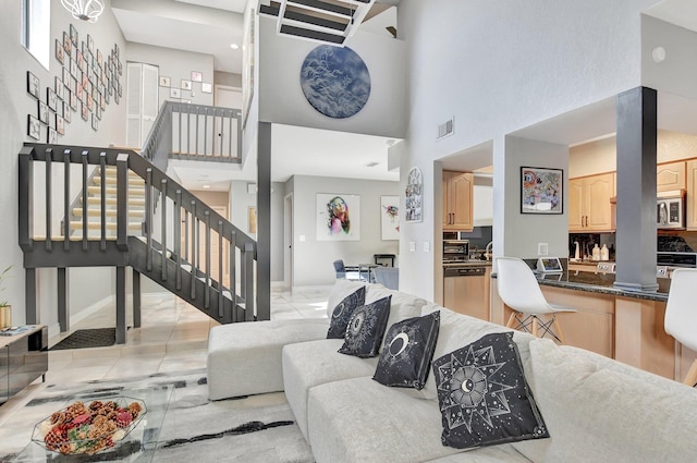 tiled living room featuring a towering ceiling