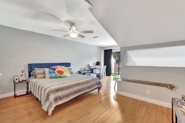 bedroom with ceiling fan, light wood-type flooring, and a textured ceiling