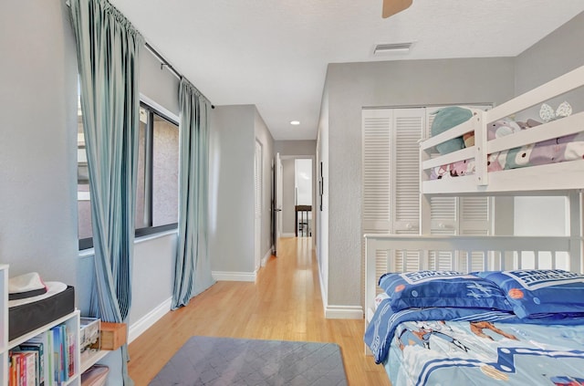 bedroom with light hardwood / wood-style floors and a closet