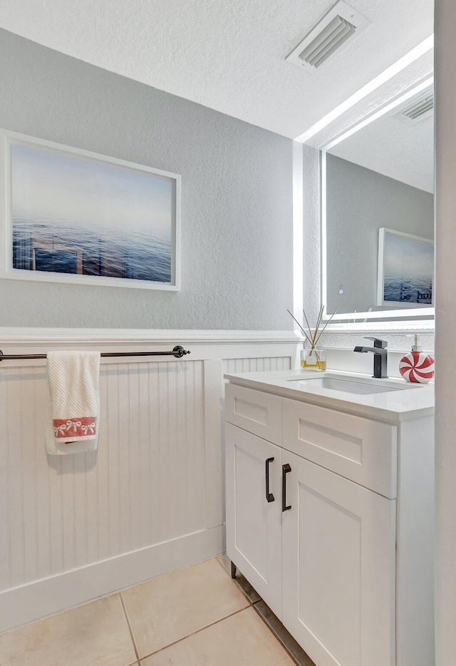 bathroom featuring tile patterned flooring, vanity, and a textured ceiling