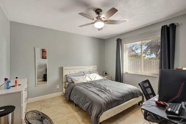 bedroom with ceiling fan, light tile patterned floors, and a textured ceiling