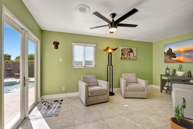 sitting room featuring ceiling fan, light tile patterned floors, and french doors