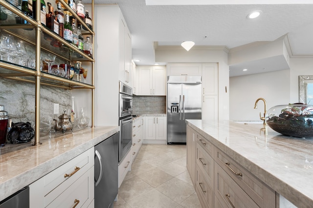 kitchen with white cabinetry, decorative backsplash, sink, and appliances with stainless steel finishes