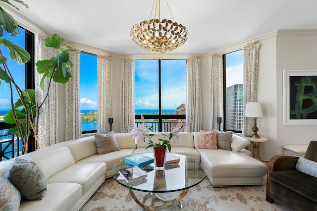 living room featuring a notable chandelier, a water view, plenty of natural light, and crown molding