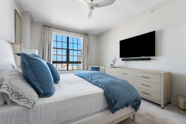 carpeted bedroom with ceiling fan and ornamental molding