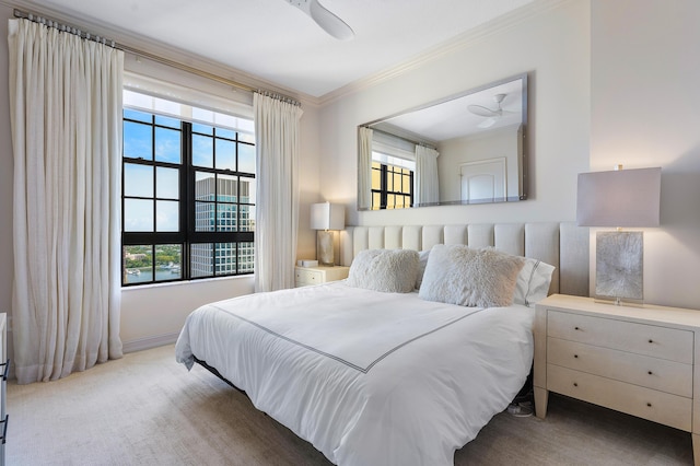 carpeted bedroom with multiple windows, ceiling fan, and crown molding