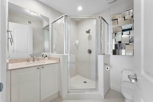 bathroom with tile patterned floors, vanity, toilet, and a shower with door