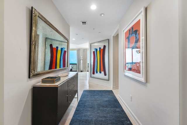 corridor with a wealth of natural light and light tile patterned floors