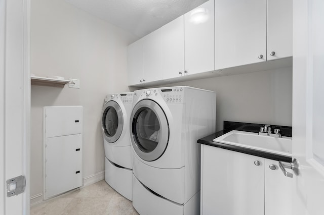 clothes washing area featuring sink, cabinets, separate washer and dryer, a textured ceiling, and light tile patterned floors