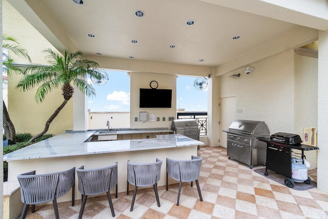 kitchen with a kitchen bar, kitchen peninsula, and light stone counters