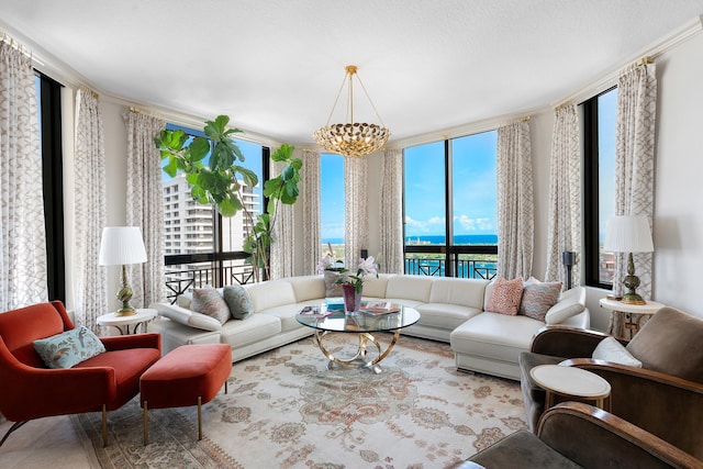 living room featuring a water view, an inviting chandelier, and a healthy amount of sunlight