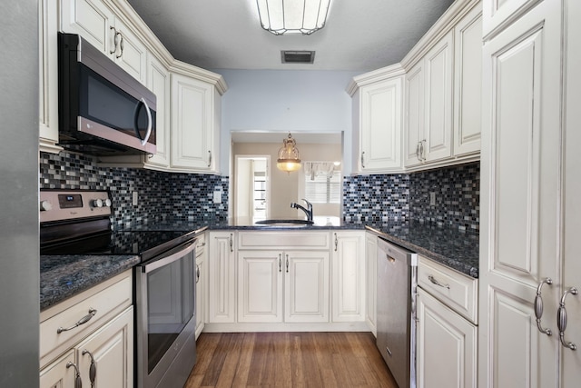 kitchen featuring decorative backsplash, sink, decorative light fixtures, and appliances with stainless steel finishes