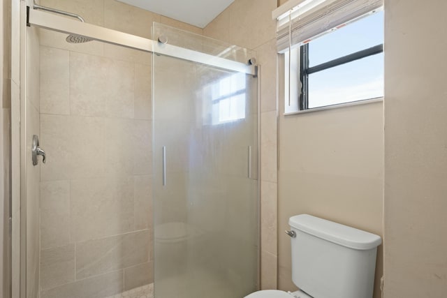 bathroom with toilet and an enclosed shower