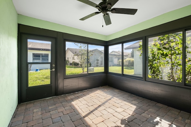 unfurnished sunroom with ceiling fan