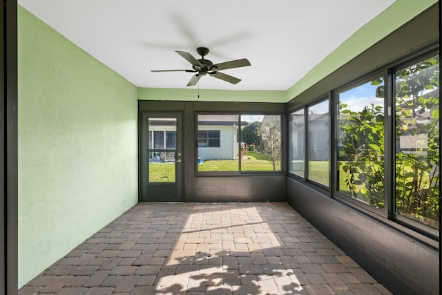 unfurnished sunroom featuring ceiling fan