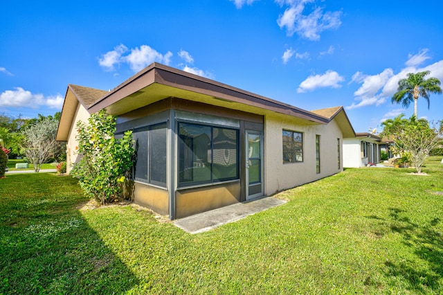 rear view of house with a sunroom and a yard