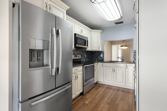 kitchen featuring backsplash, dark hardwood / wood-style flooring, stainless steel appliances, and sink