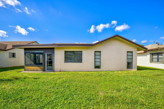 back of house featuring a yard and a sunroom