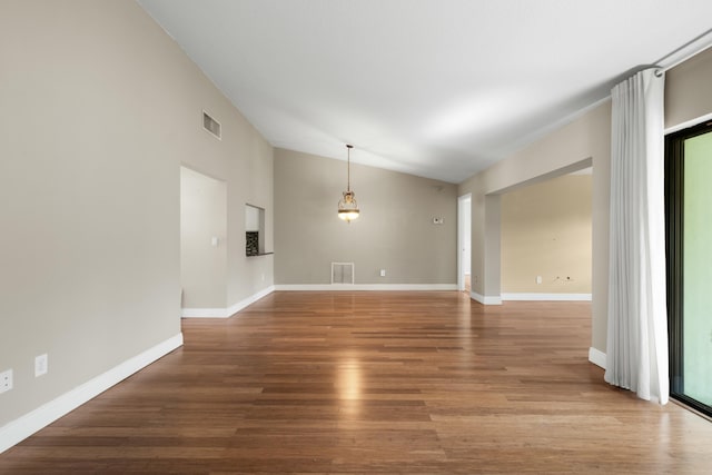 spare room featuring vaulted ceiling and hardwood / wood-style flooring