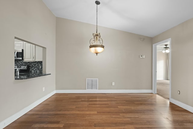 unfurnished dining area with ceiling fan, dark hardwood / wood-style flooring, and lofted ceiling