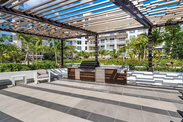 view of patio featuring area for grilling, a pergola, and exterior kitchen